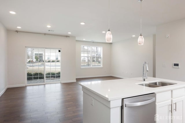 kitchen with a sink, white cabinets, open floor plan, dishwasher, and decorative light fixtures