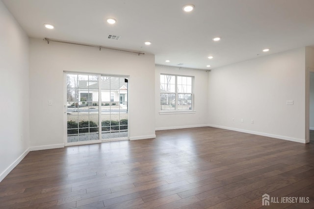 spare room with baseboards, visible vents, dark wood finished floors, and recessed lighting