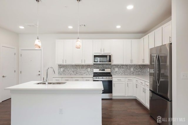 kitchen with a sink, stainless steel appliances, visible vents, and dark wood finished floors