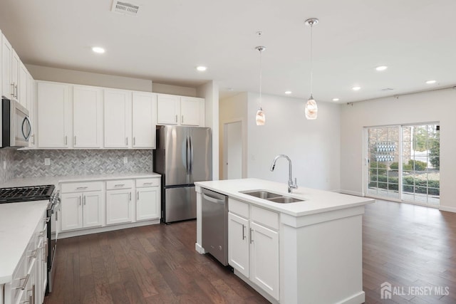 kitchen featuring a kitchen island with sink, stainless steel appliances, a sink, visible vents, and light countertops