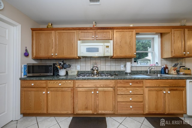 17 Duane St, Jamesburg, NJ 08831 - kitchen with stainless steel appliances, light tile patterned floors, tasteful backsplash, and brown cabinetry