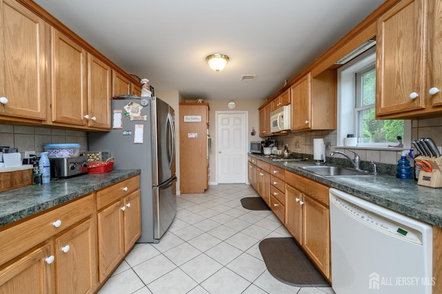 17 Duane St, Jamesburg, NJ 08831 - kitchen with stainless steel appliances, tasteful backsplash, light tile patterned floors, and dark countertops
