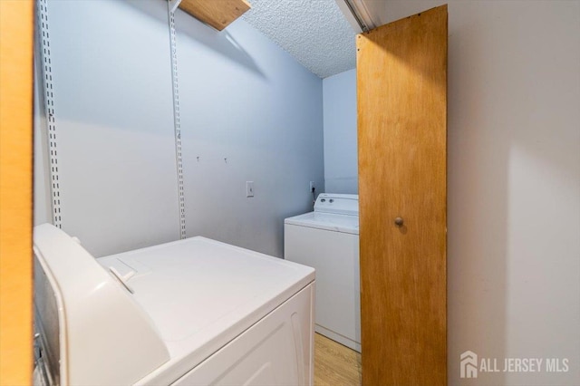 36 Henry St, Edison, NJ 08820 - laundry room featuring separate washer and dryer, a textured ceiling, and light wood-style flooring