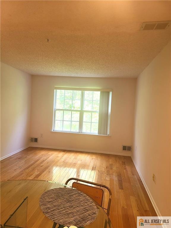 297 Prestwick Way Unit 297, Edison, NJ 08820 - empty room with light wood finished floors, baseboards, and a textured ceiling