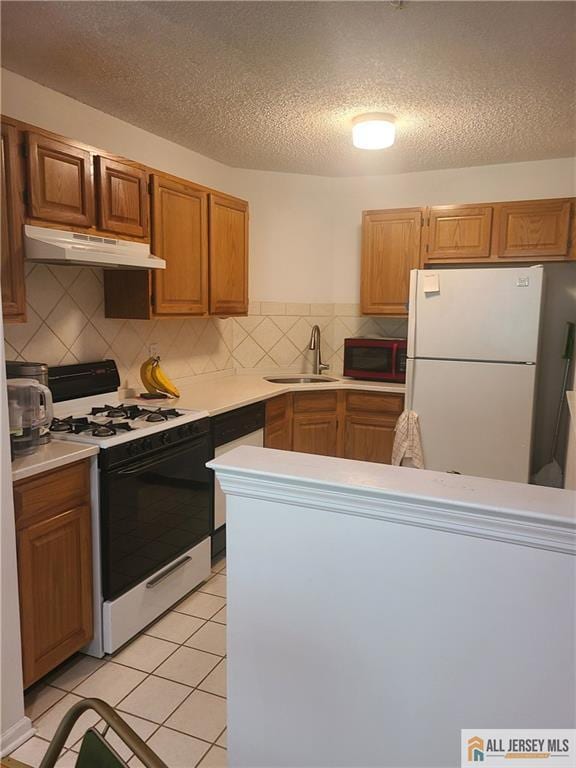 297 Prestwick Way Unit 297, Edison, NJ 08820 - kitchen featuring white appliances, under cabinet range hood, a sink, light countertops, and tasteful backsplash