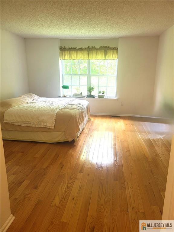 297 Prestwick Way Unit 297, Edison, NJ 08820 - bedroom featuring a textured ceiling, light wood-style floors, and baseboards