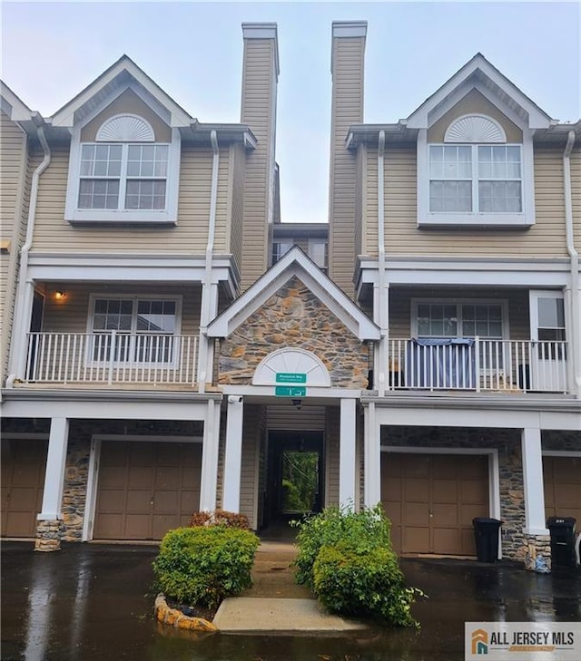 297 Prestwick Way Unit 297, Edison, NJ 08820 - view of front of home featuring a balcony, an attached garage, stone siding, and a chimney