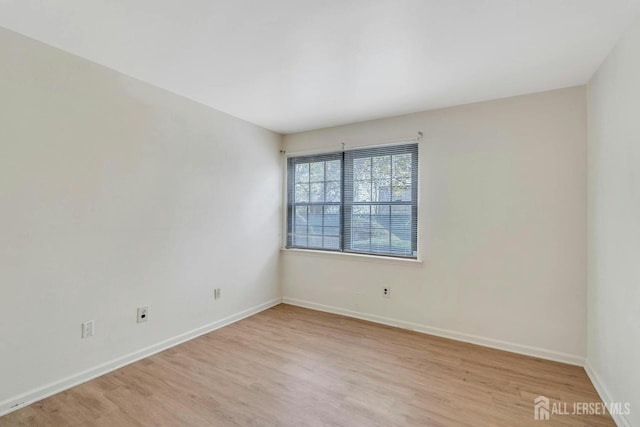 unfurnished room featuring baseboards and light wood finished floors