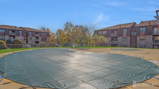 community pool featuring a residential view, a patio, and fence