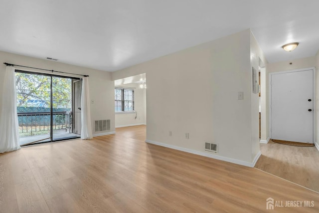 unfurnished living room featuring visible vents, baseboards, and light wood finished floors