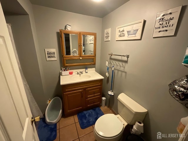 bathroom featuring tile patterned flooring, vanity, and toilet