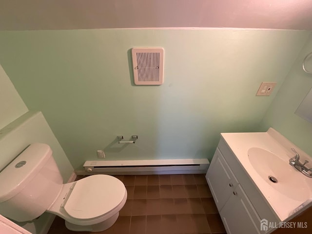 bathroom with tile patterned flooring, a baseboard radiator, vanity, and toilet