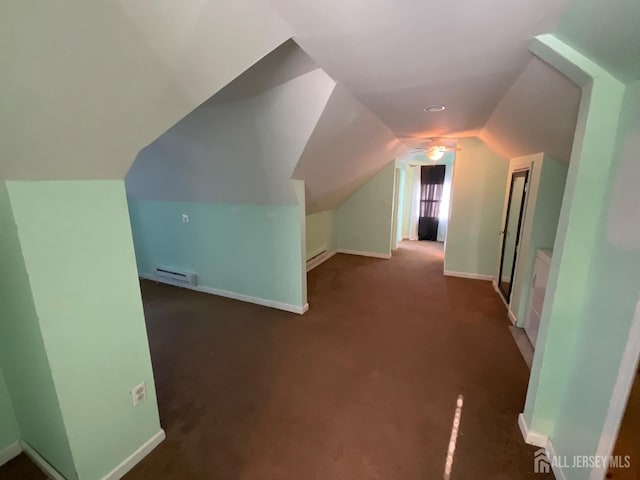 additional living space featuring vaulted ceiling, baseboard heating, and dark colored carpet