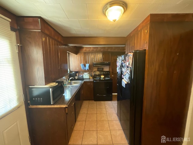 kitchen featuring sink, light tile patterned floors, and black appliances