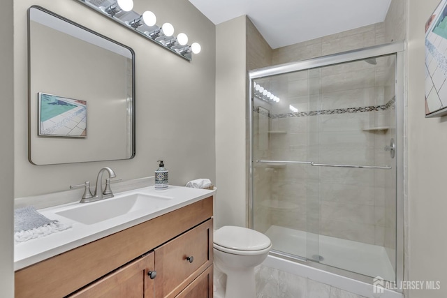 bathroom featuring toilet, a stall shower, and vanity