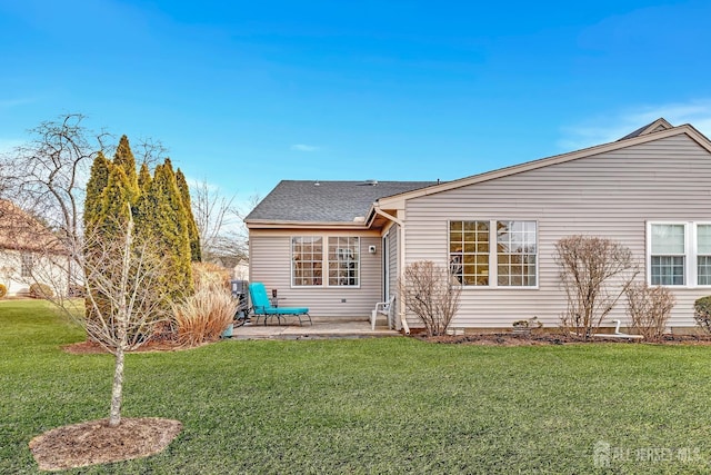 rear view of house with a patio area, roof with shingles, and a yard