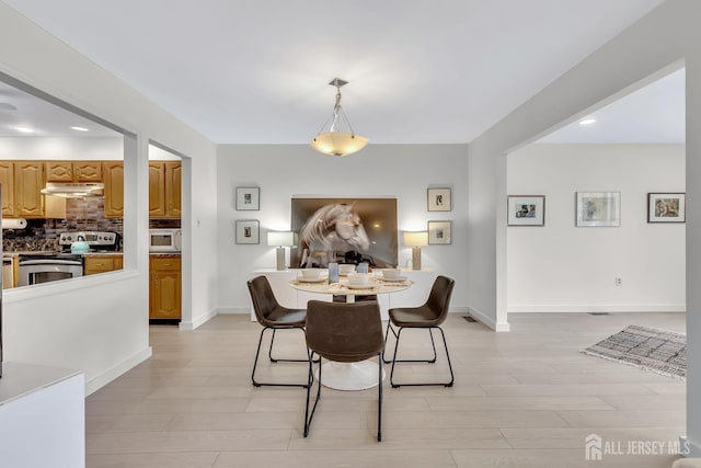 dining area with light wood finished floors, baseboards, and recessed lighting