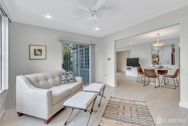 living area featuring ceiling fan, light wood finished floors, baseboards, and recessed lighting