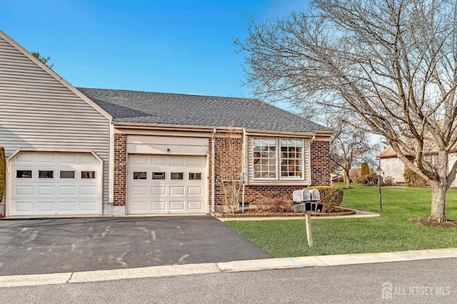 view of front of house featuring brick siding, a front lawn, an attached garage, and aphalt driveway