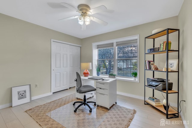 home office featuring ceiling fan, light wood finished floors, and baseboards