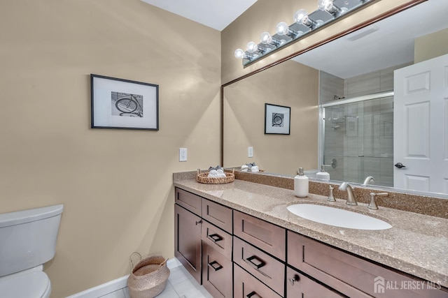 full bath featuring tile patterned flooring, toilet, vanity, baseboards, and a stall shower