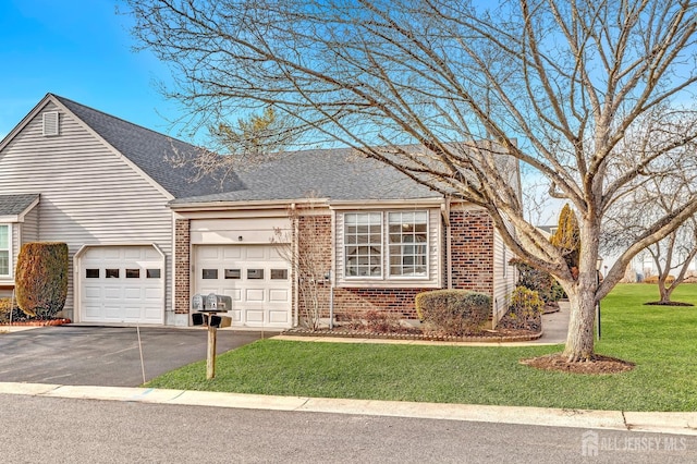 view of front of house featuring a garage, driveway, a front lawn, and brick siding