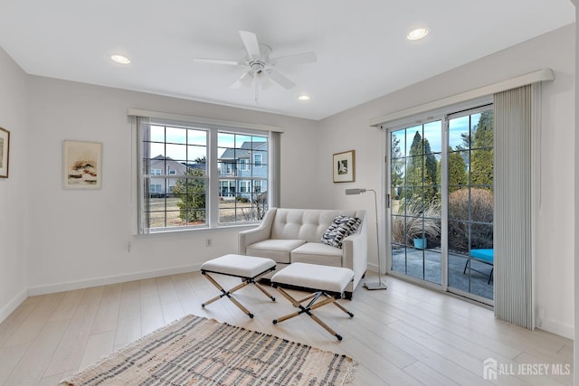 living area with light wood-type flooring, baseboards, and recessed lighting