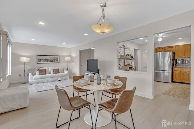 dining room featuring light wood-type flooring, baseboards, and recessed lighting