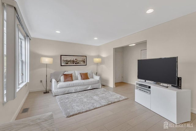 living area featuring light wood-type flooring, a wealth of natural light, and recessed lighting