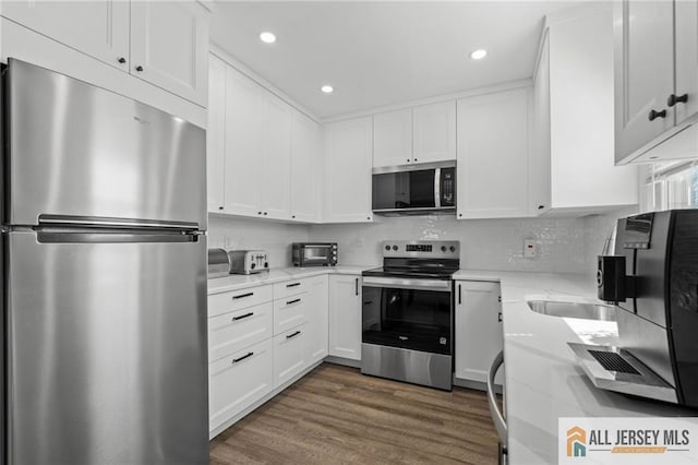 479 Newport Way, Monroe, NJ 08831 - kitchen with appliances with stainless steel finishes, white cabinetry, dark wood-style floors, recessed lighting, and backsplash