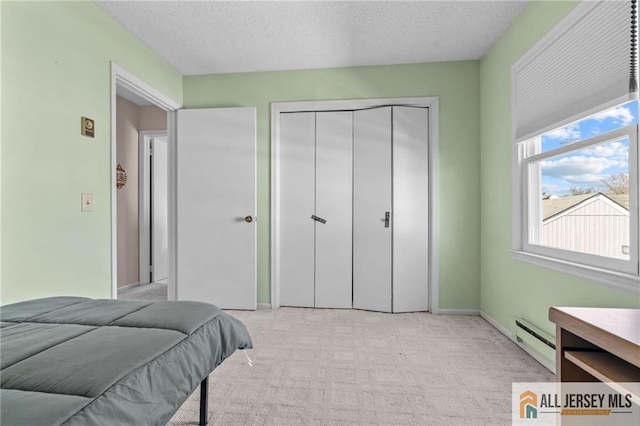 479 Newport Way, Monroe, NJ 08831 - bedroom featuring a baseboard heating unit, a closet, light colored carpet, a textured ceiling, and baseboards