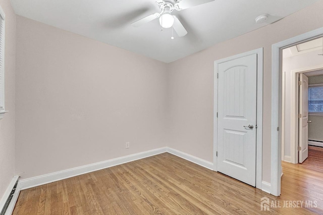 unfurnished bedroom with light wood-type flooring, ceiling fan, and baseboard heating