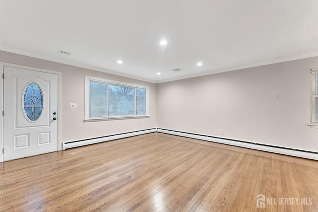 foyer entrance featuring a baseboard heating unit, crown molding, and light wood-type flooring