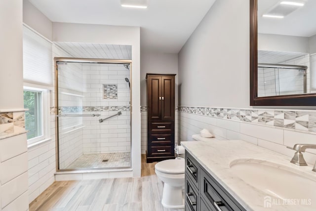 20 Buffalo Run, East Brunswick, NJ 08816 - bathroom featuring tile walls, vanity, a shower stall, wood finished floors, and a wainscoted wall