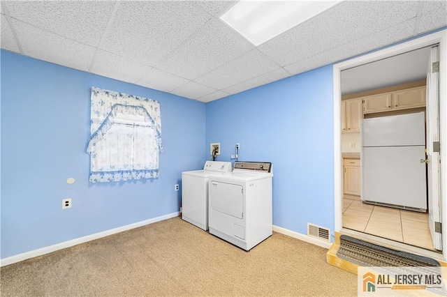 washroom featuring cabinets, light carpet, and washing machine and clothes dryer