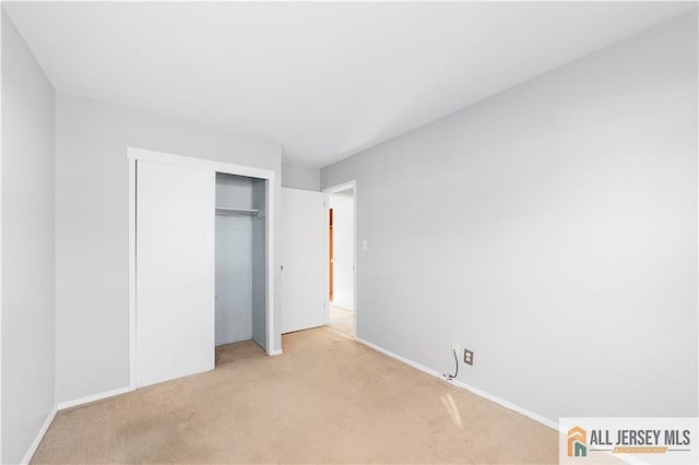 unfurnished bedroom featuring a closet and light carpet