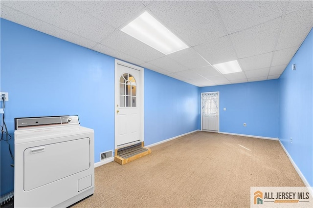 interior space featuring washer / dryer, a paneled ceiling, and light colored carpet