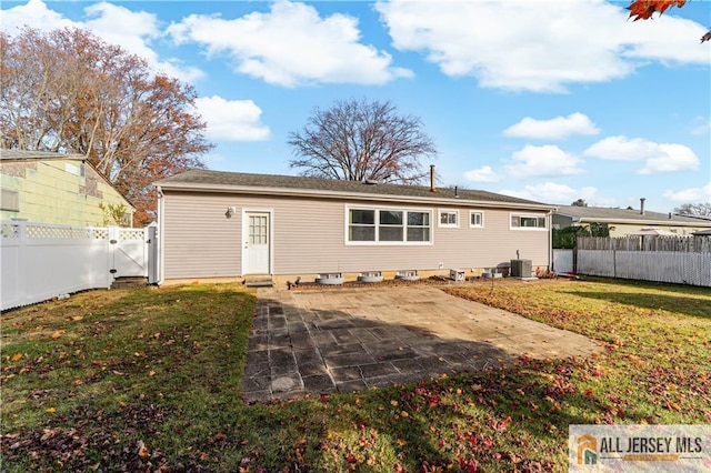 rear view of property featuring a patio, cooling unit, and a lawn