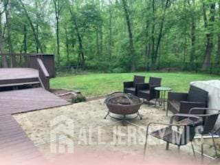 view of patio with an outdoor fire pit and a deck