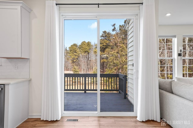 doorway to outside with recessed lighting, visible vents, plenty of natural light, and light wood-style flooring