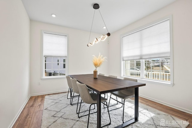 dining area featuring light wood finished floors, baseboards, and recessed lighting