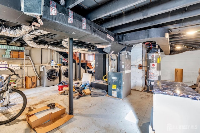 basement with heating unit, washer and clothes dryer, and water heater