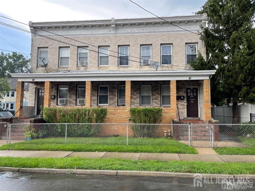 82 Pulaski Ave, Carteret, NJ 07008 - view of property with covered porch, brick siding, a gate, and a fenced front yard