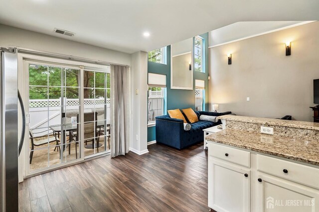 kitchen featuring white cabinetry, light stone counters, plenty of natural light, and stainless steel refrigerator