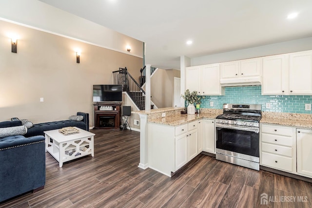 kitchen featuring white cabinets, kitchen peninsula, tasteful backsplash, and stainless steel gas range oven