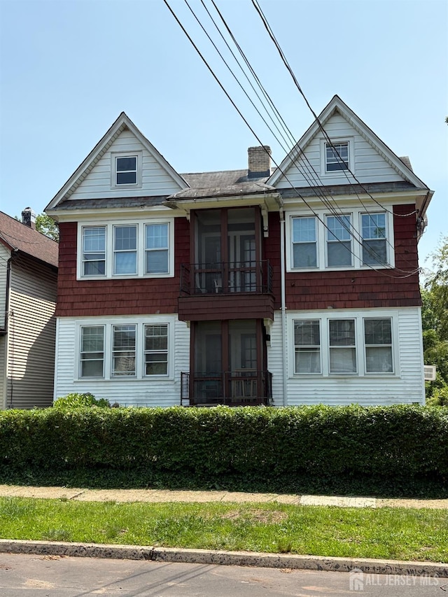 214 Montgomery St, Highland Park, NJ 08904 - view of front of house with a balcony, a chimney, and roof with shingles