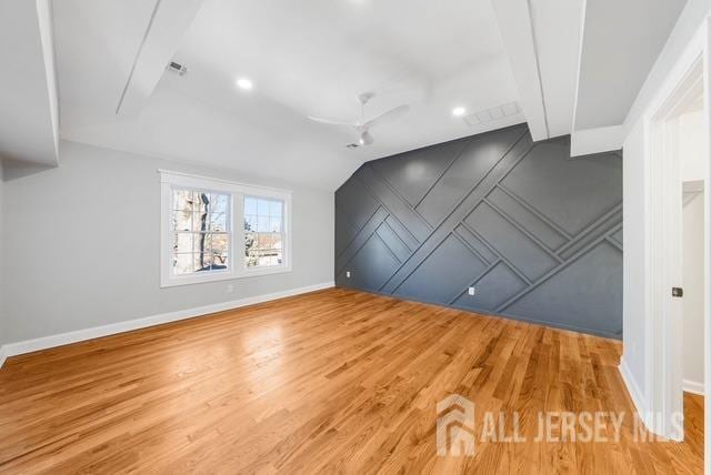 bonus room featuring a ceiling fan, vaulted ceiling, baseboards, and wood finished floors