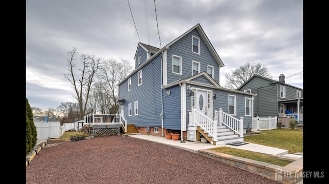 view of front of house featuring fence and a front lawn