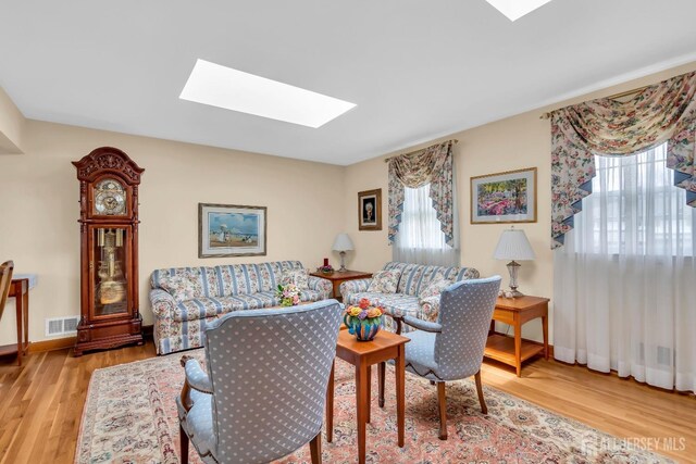 423 Brentwood Dr, Piscataway, NJ 08854 - living room featuring a skylight, light wood-style floors, and baseboards