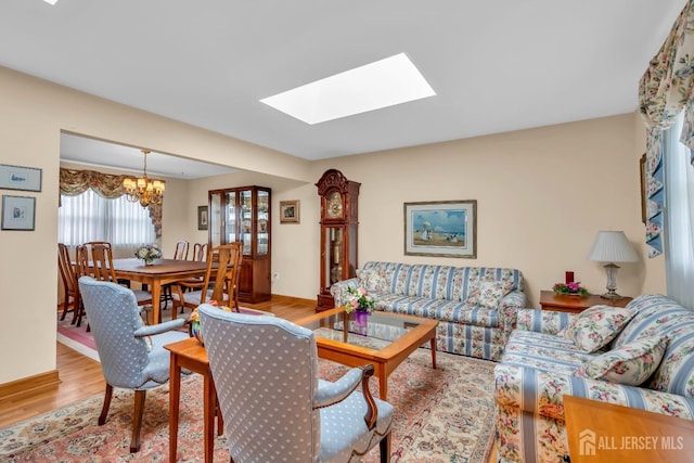 423 Brentwood Dr, Piscataway, NJ 08854 - living area featuring wood finished floors, a chandelier, a skylight, and baseboards